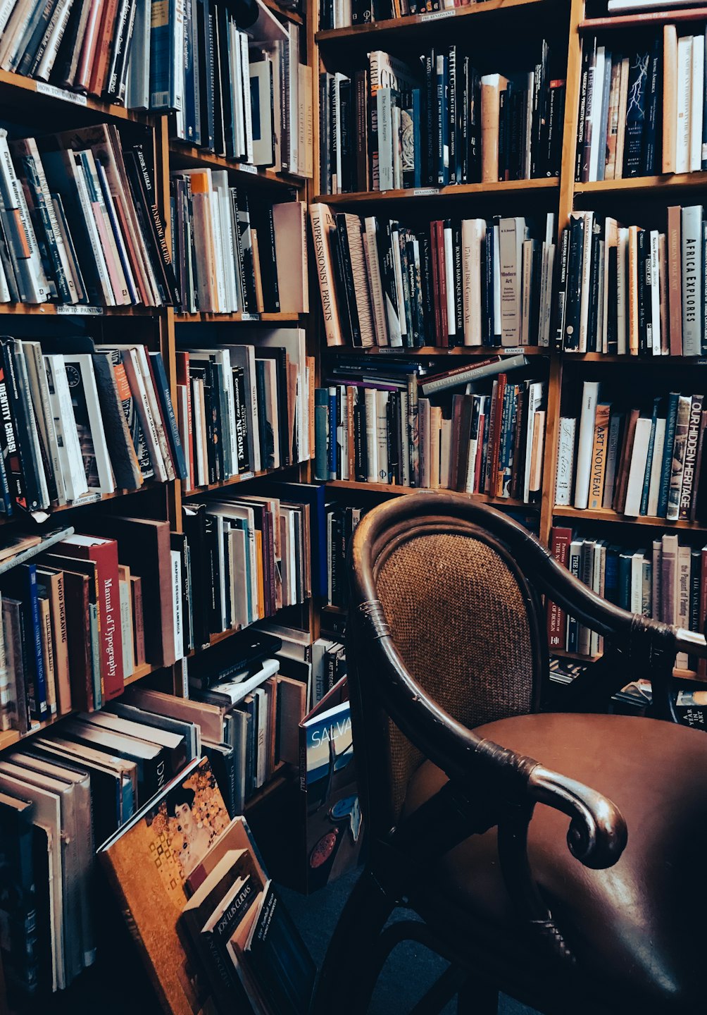 Cozy library corner with overflowing bookshelves and armchair.