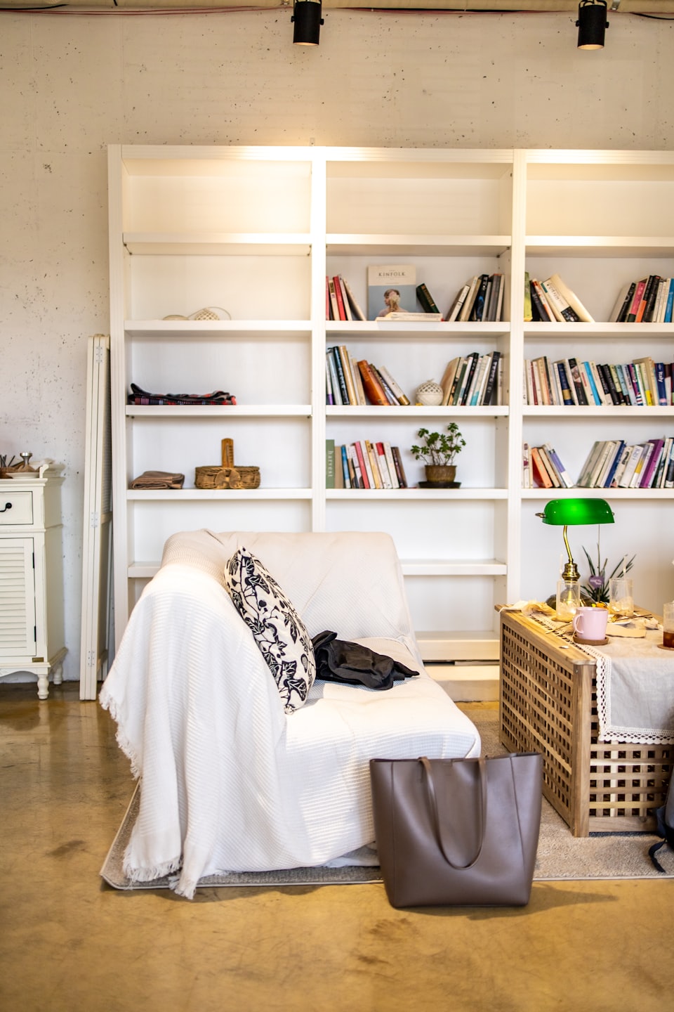 Reading nook with an armchair, books, and a lamp.